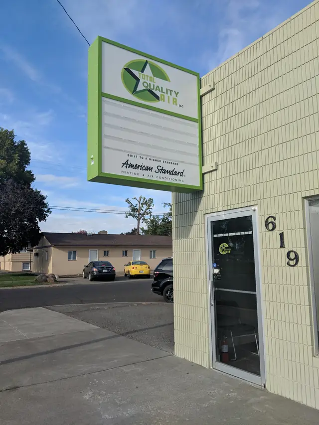 Total Quality Air storefront at 619 N 3rd Ave, Pasco: cream glazed block, the green star sign with its American Standard panel, and the glass door