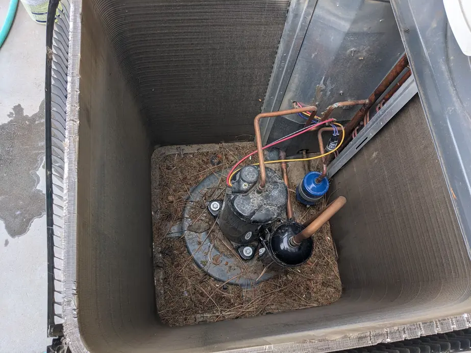 Condenser interior packed with pine needles before a maintenance cleaning