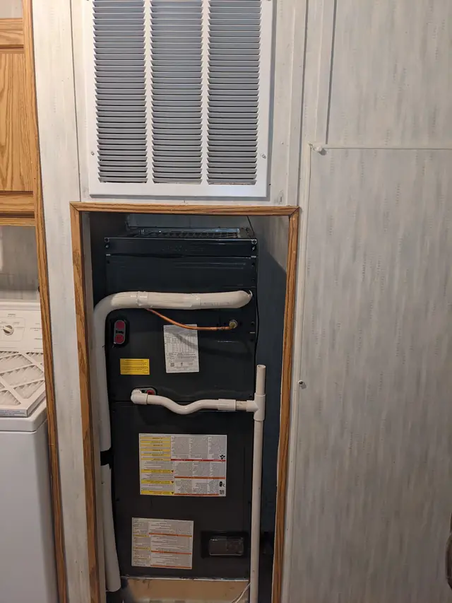 Furnace in a hallway closet under a return grille, serviced by Total Quality Air